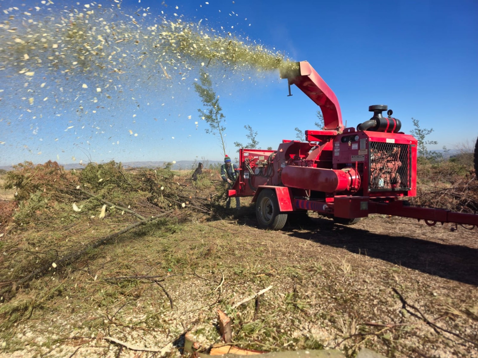 Commercial wood chipper processing cleared branches on a Gauteng land clearing site